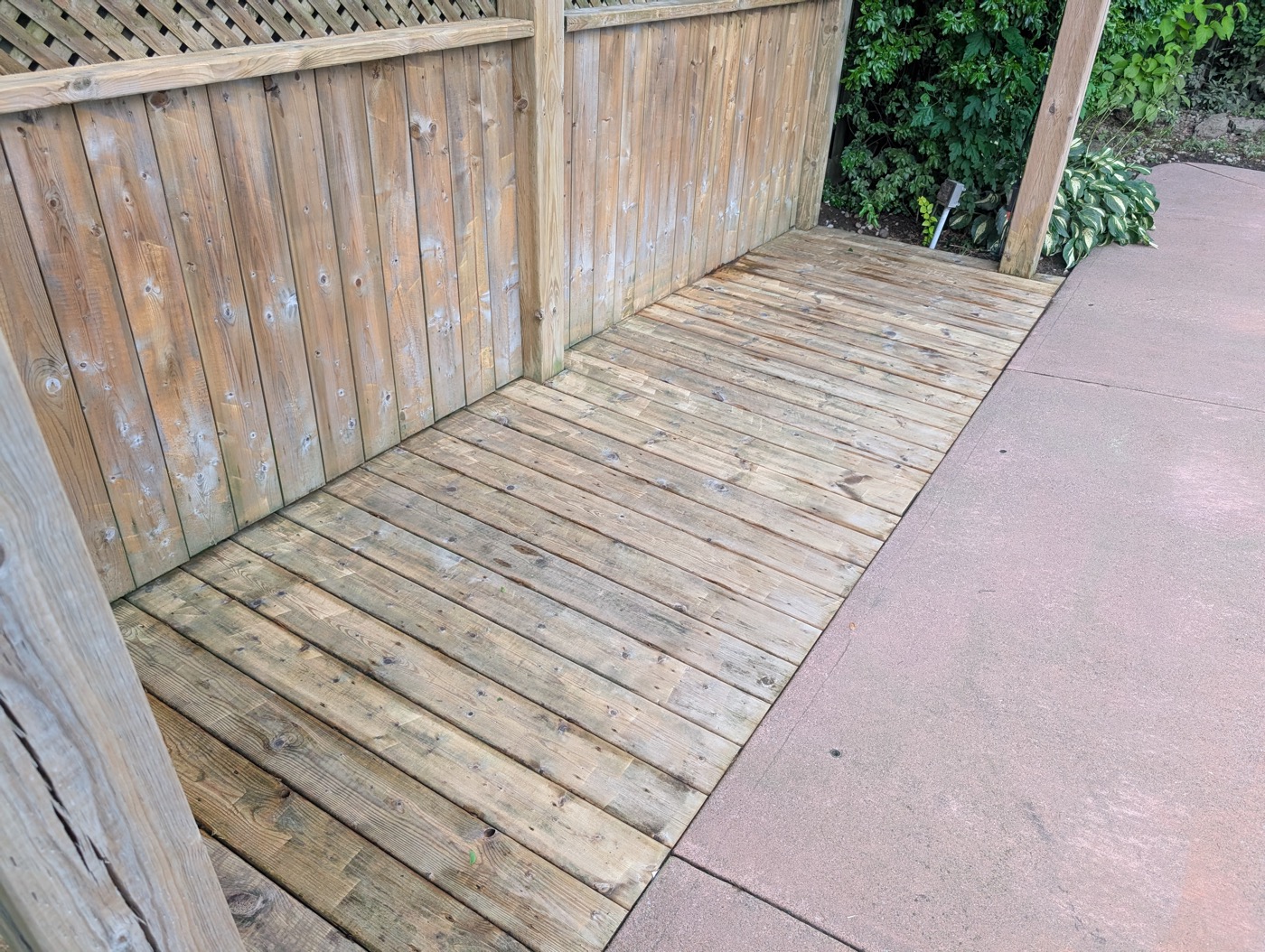Same wood deck after pressure washing, restored to a light natural wood tone
