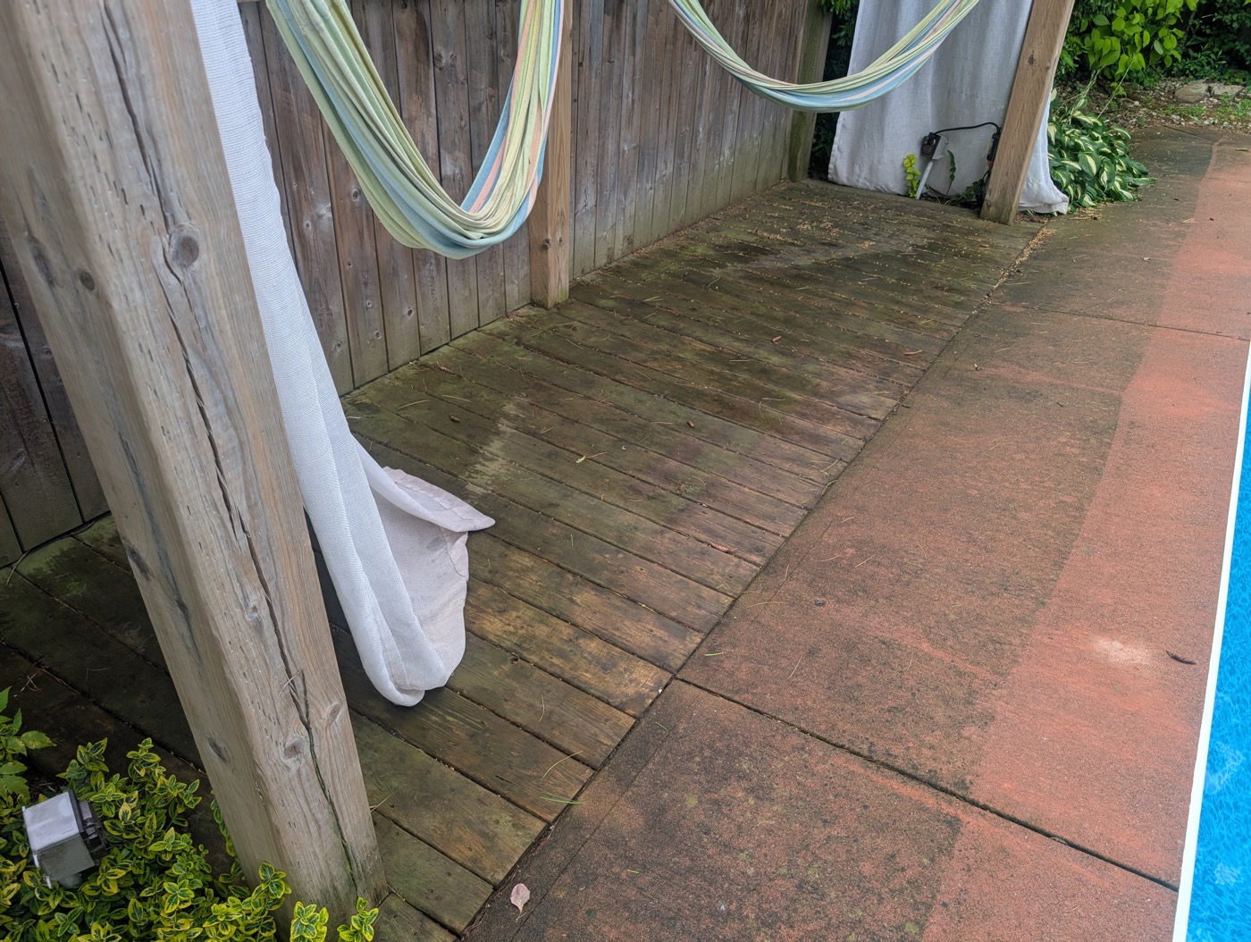 Wood deck before pressure washing, dark with algae and grime