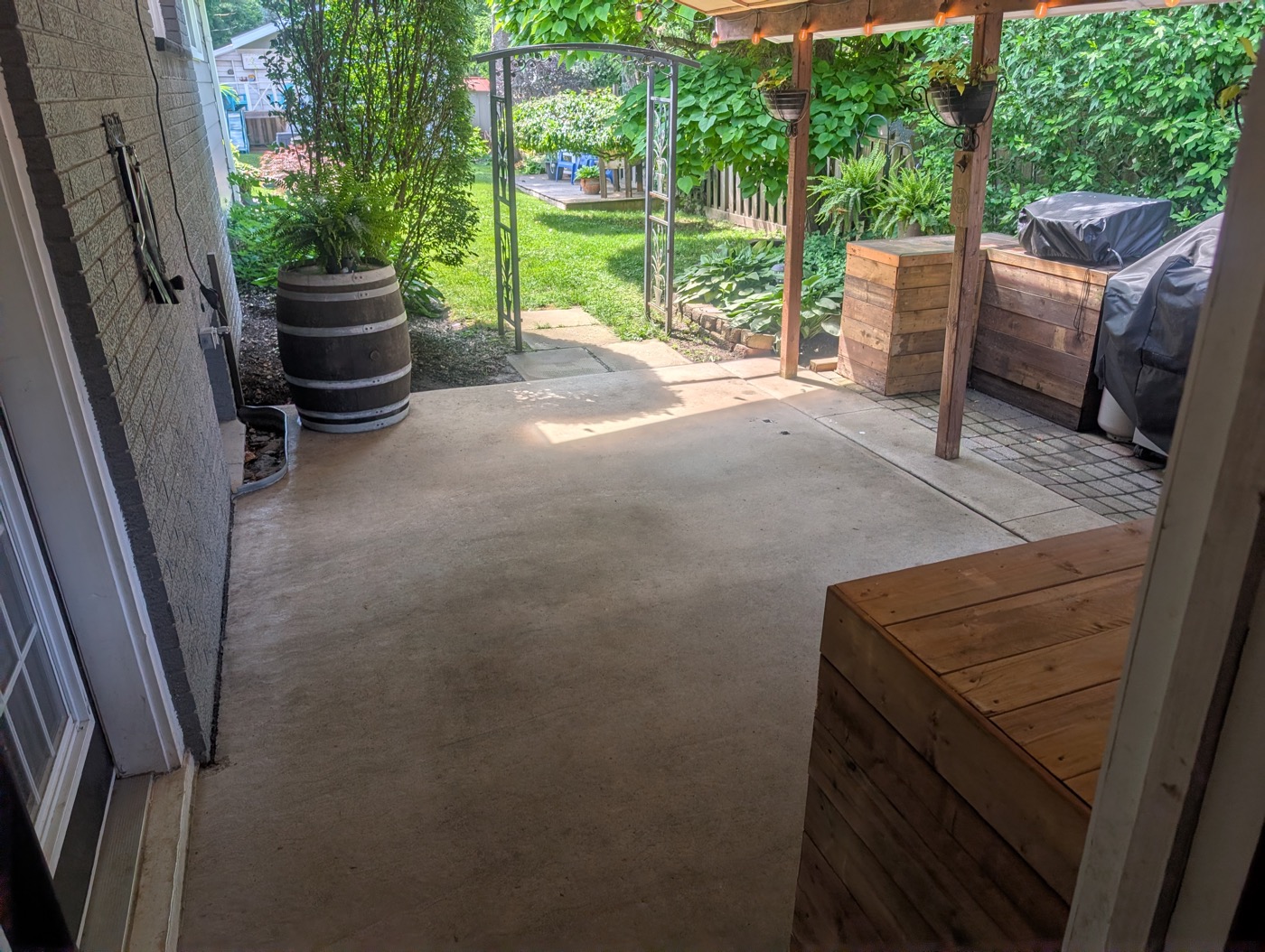 Same concrete patio after pressure washing, restored to a clean, even finish