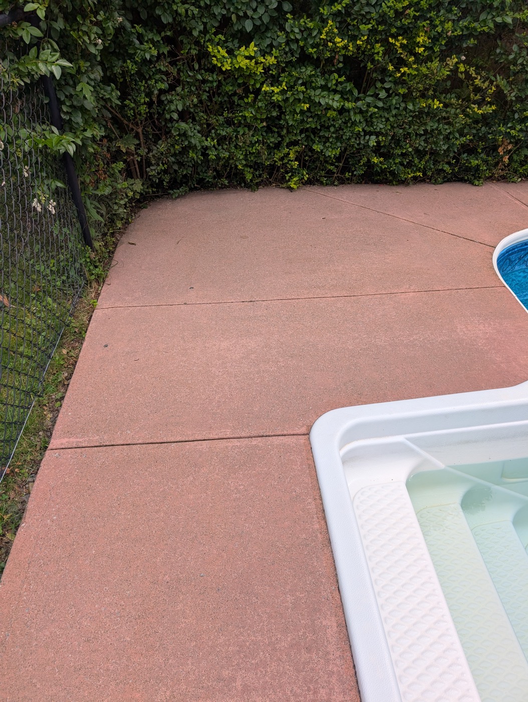 Same pool deck concrete after pressure washing, restored to an even clean finish